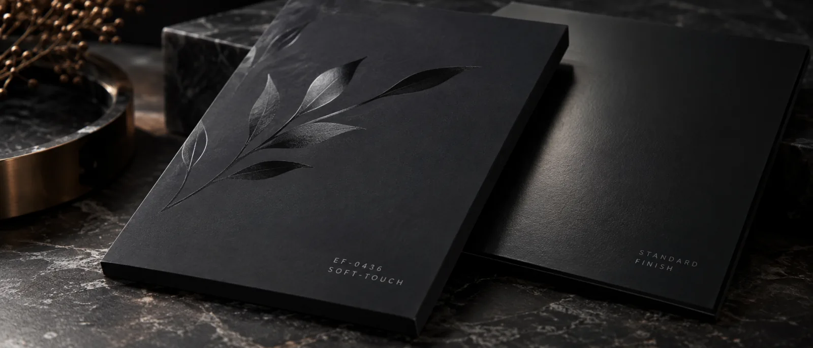 One piece of artwork laminated both ways on the same board and set side by side under one light: the matte panel holding no highlight at all, the gloss panel carrying a reflection across the top of the same flower.