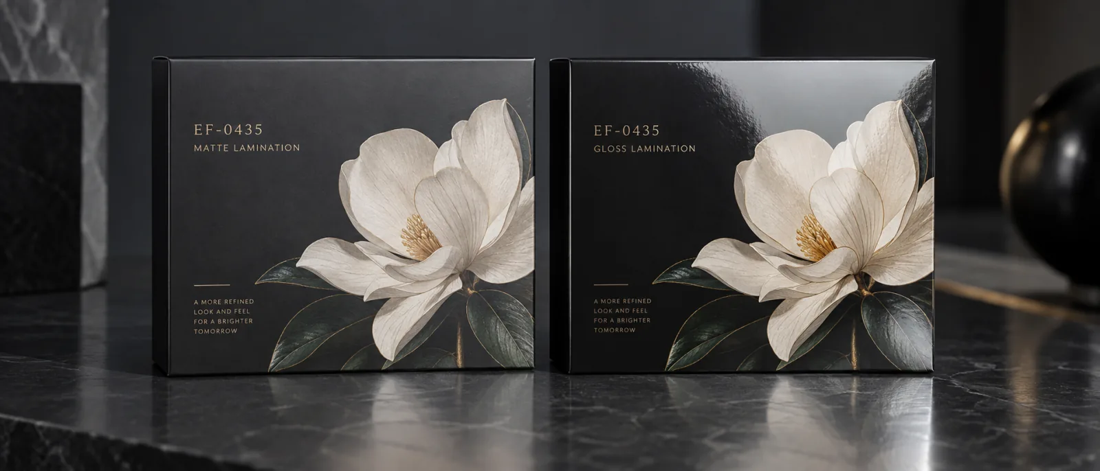 Two panels of the same black board under one light, the soft touch one carrying a marked botanical that catches the light where the surface around it holds none, and a standard finished panel beside it for the difference.