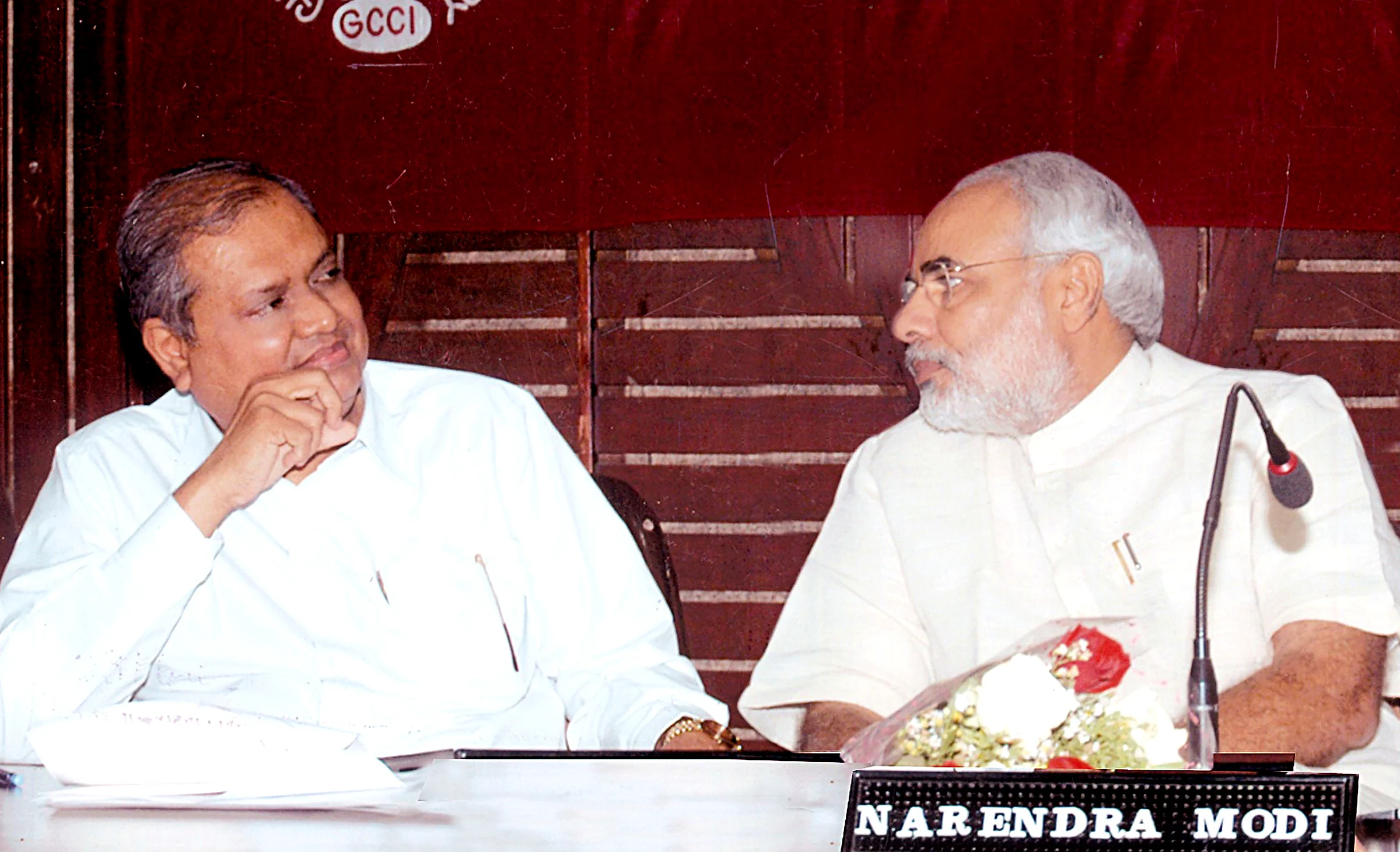 Seated beside Narendra Modi at the head table of the Gujarat Chamber of Commerce and Industry.