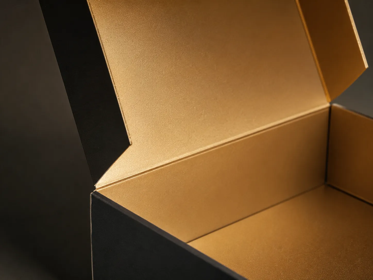 Open two piece carton showing a foil printed interior panel under warm light