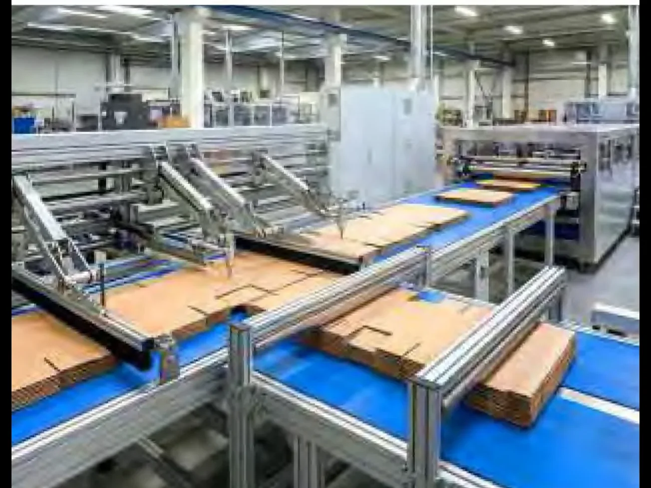 Cartons running along the folder gluer line, each blank closing and its seam pressed