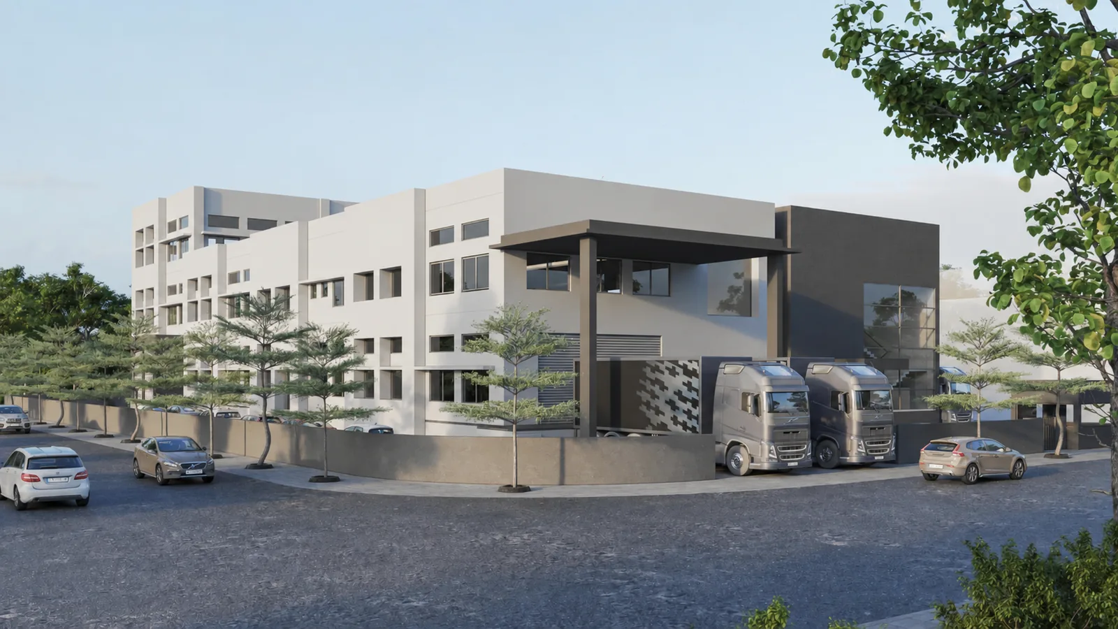 The Eastface plant in Piplaj on the edge of Ahmedabad, seen from the street: a three story white and graphite block with a covered entrance canopy, trucks standing at the bay beside a perforated screen wall, and young trees along the boundary.