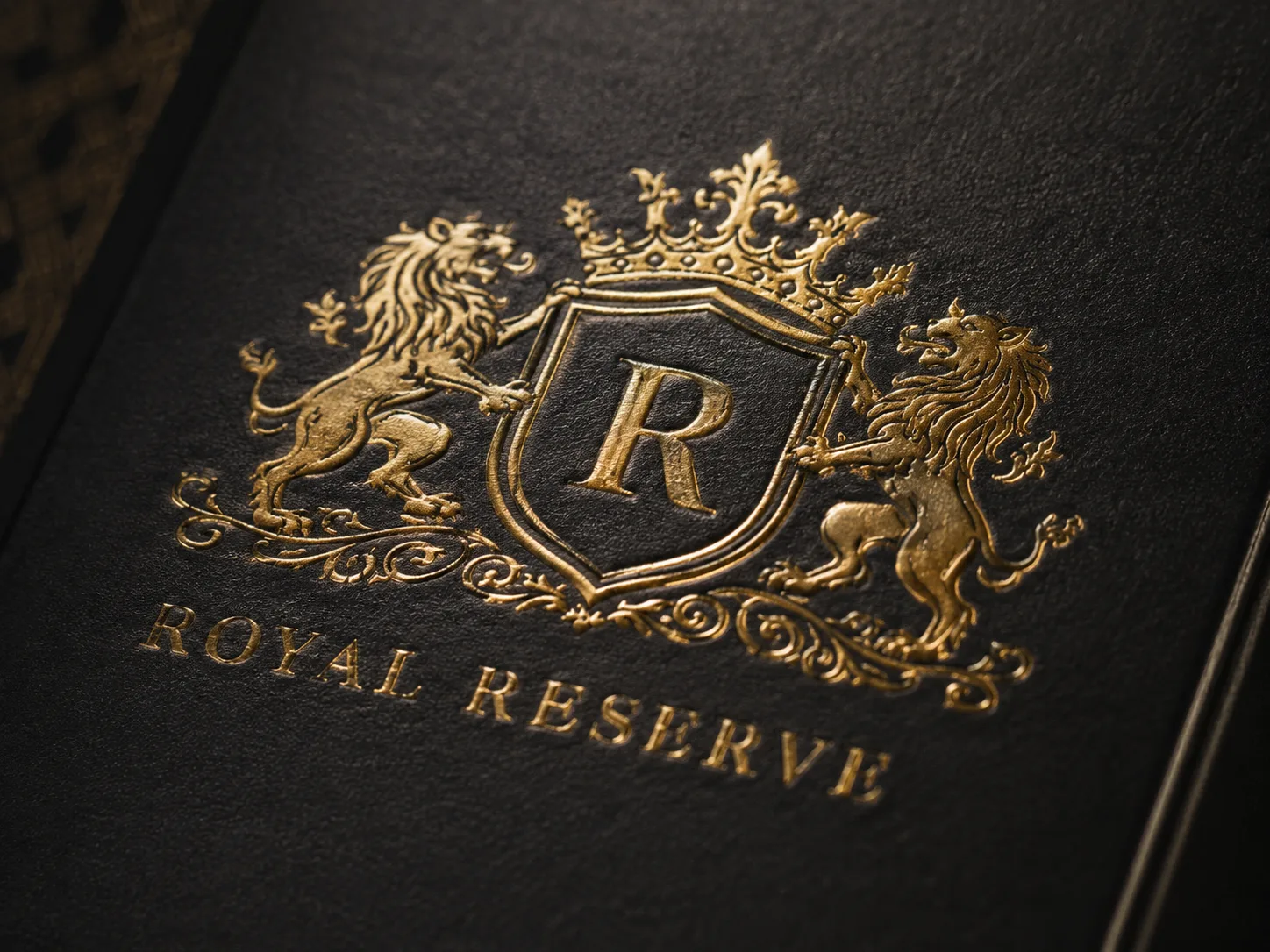 A gold foil crest stamped into black board, the relief of the die visible along every edge