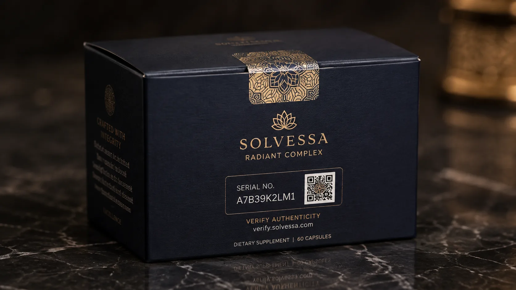 A navy capsule carton on dark marble, a gold patterned tamper band across the lid and a serial number with a scan code on the face