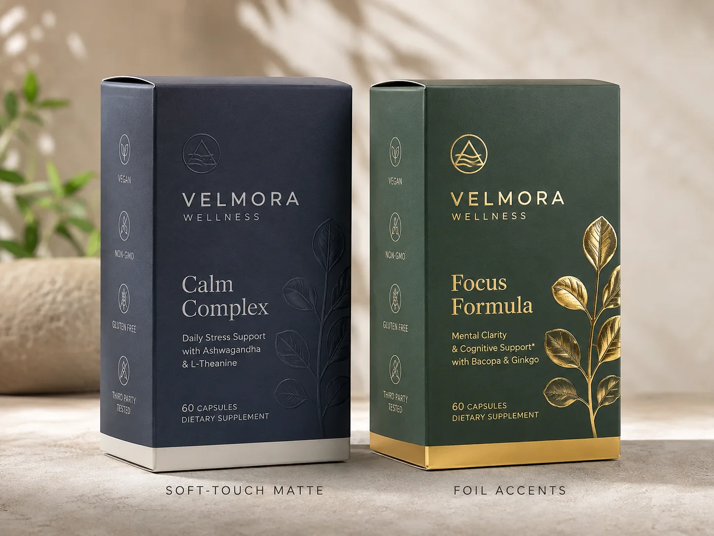 Two capsule cartons side by side, one in soft touch matte with a blind emboss and one in deep green with gold foil leaf work