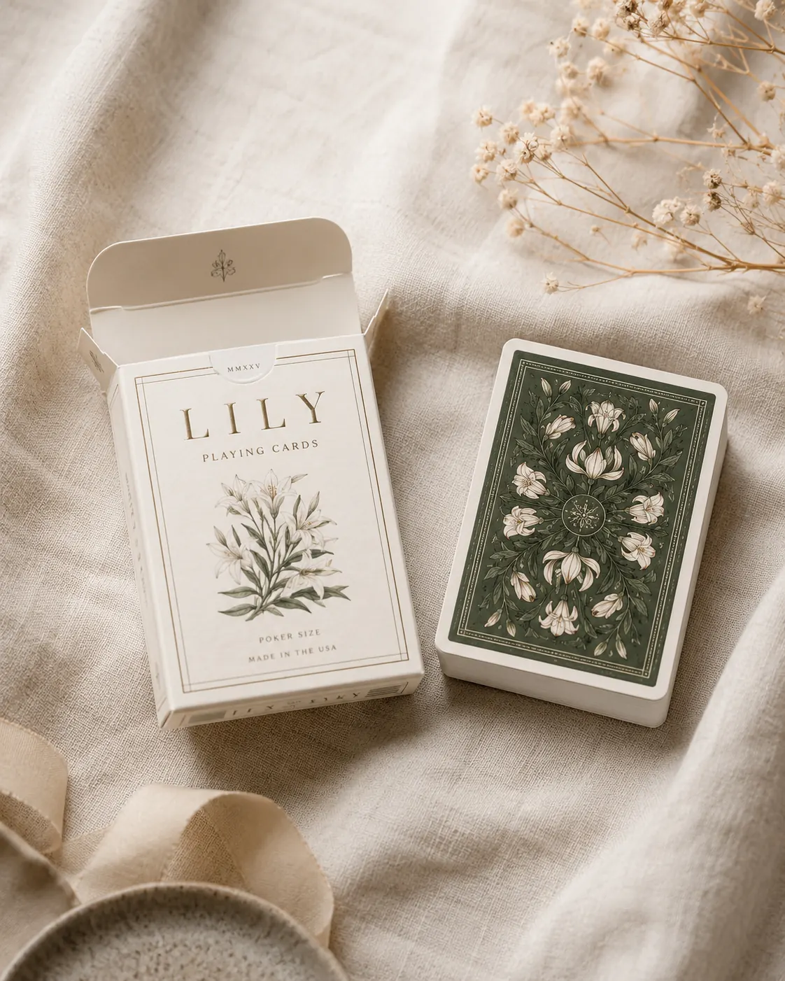 An open cream tuck box on linen beside the printed card deck it was drawn around