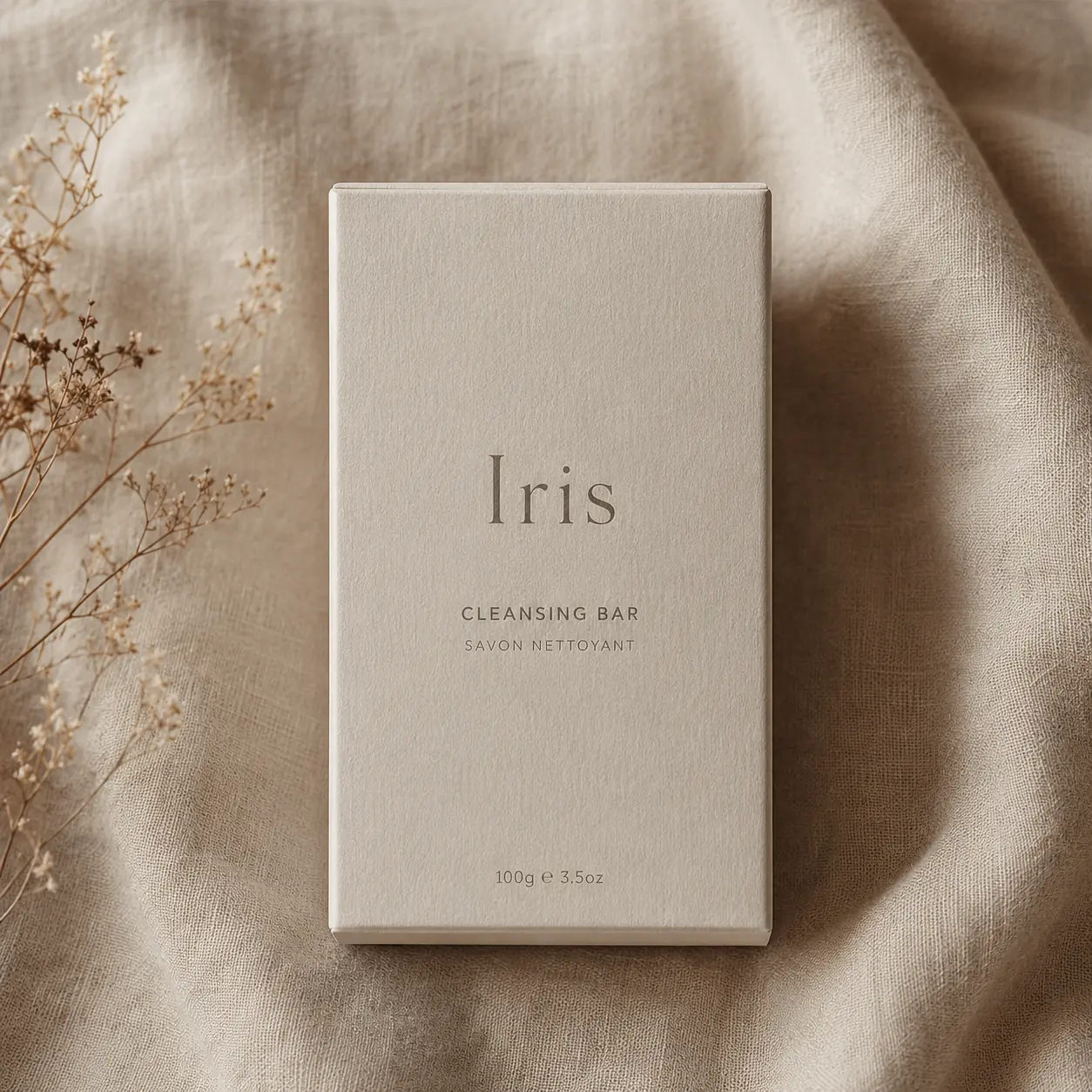 A cream cleansing bar carton lying face up on linen, the front panel unbroken by any crease or flap edge